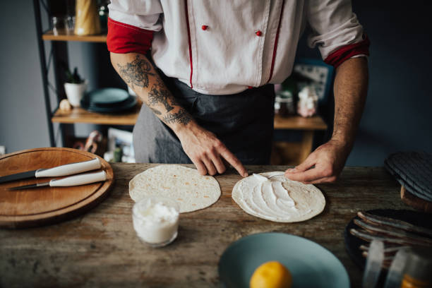 istock Chef smear cream on tortilla 698753366
