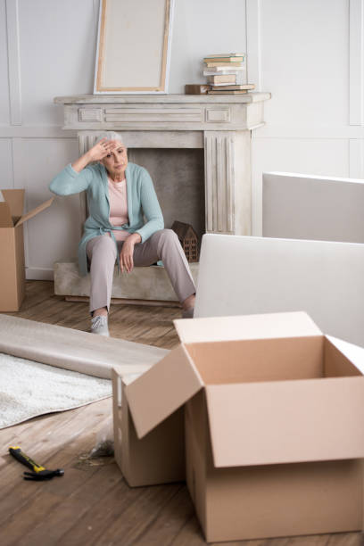 istock tired senior woman having rest on fireplace after unpacking boxes 698759024