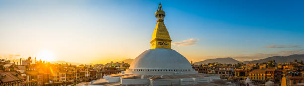 Golden spire Buddhist stupa temple illuminated sunset Boudhanath Kathmandu Nepal The iconic mandala dome of Boudhanath stupa, illuminated by warm sunset light as crowds of pilgrims and tourists walk around the ancient Buddhist shrine, a UNESCO World Heritage Site in Kathmandu, Nepal's vibrant capital city. thamel stock pictures, royalty-free photos & images