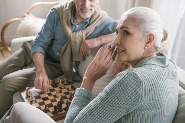 istock casual grey haired couple playing chess at home 698759748