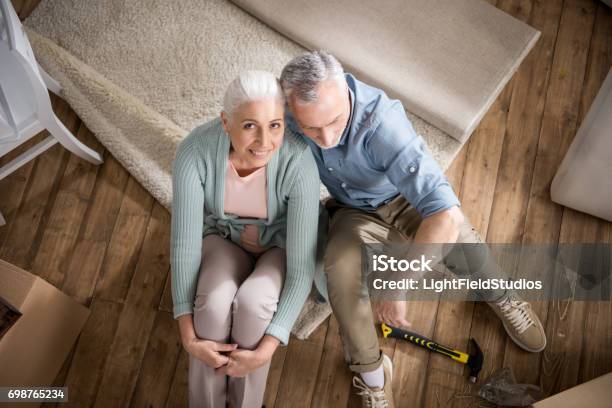 Älteres Paar Schatz Umarmen Beim Sitzen Auf Dem Boden Zu Hause Stockfoto und mehr Bilder von Alter Erwachsener