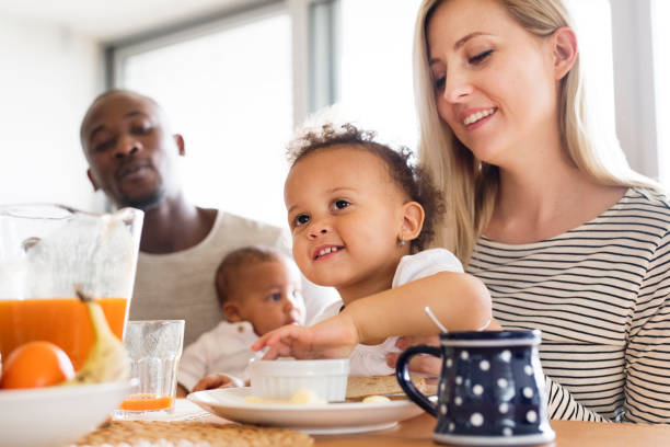 istock Young interracial family with little children having breakfast. 698765970