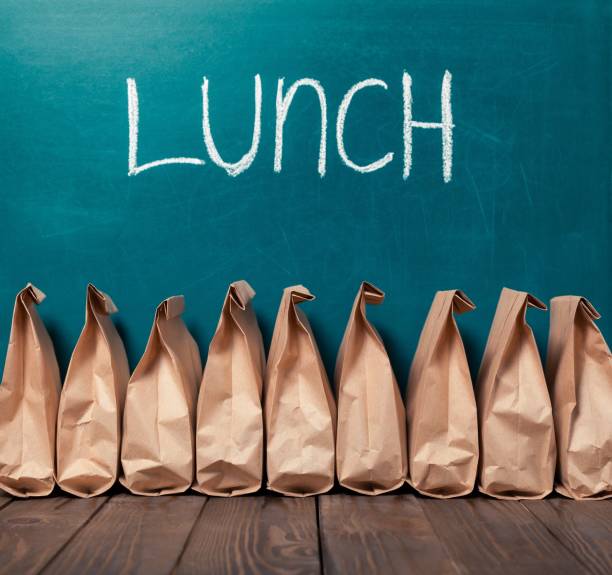 Lunch. Paper bags in row against blackboard background and word Lunch lunch stock pictures, royalty-free photos & images