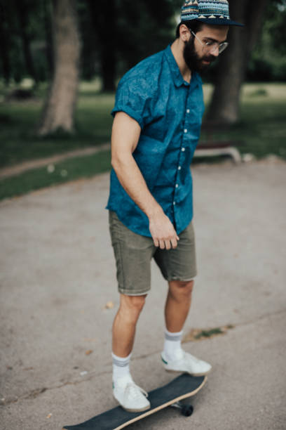 istock Bearded skater riding skateboard in the park 698791396