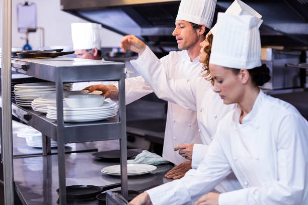 istock Team of chefs arranging plates on the order station 698801232