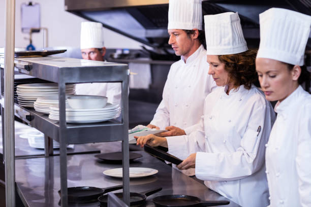 istock Team of chefs arranging plates on the order station 698802186