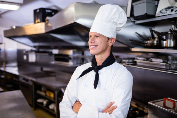 istock Happy male chef standing with arms crossed 698807842