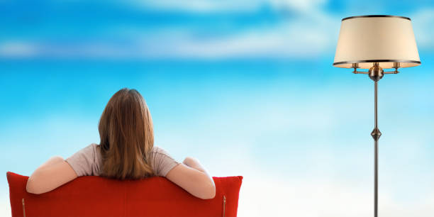 mujer relajante en un sofá y mirando fuera hermosa fondo vista al mar. - 5461 fotografías e imágenes de stock