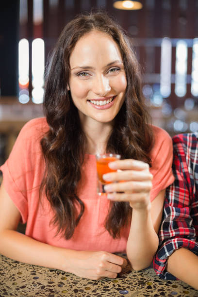 istock Woman looking at camera with shot in hand 698809302