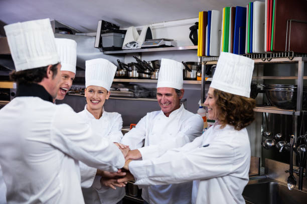 istock Team of chefs putting hands together and cheering 698810048