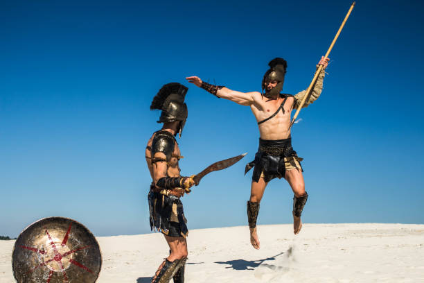 istock An ancient warrior with a spear in a jump attacks the Spartan 698810184