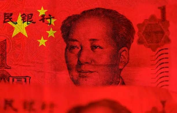 Photo of Chinese money, flag of China and face of Mao Zedong