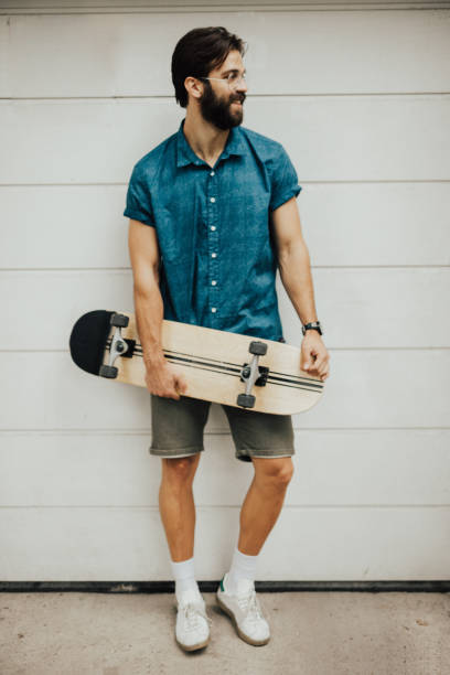 istock Man leaned on the wall is holding a skateboard 698810612