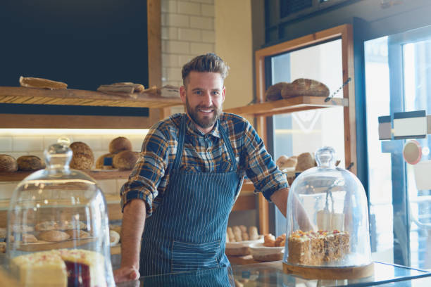 It doesn't get fresher than this Portrait of a young business owner standing behind the counter in his bakery small business saturday stock pictures, royalty-free photos & images