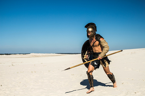 Spartan quickly runs through the sand with weapons