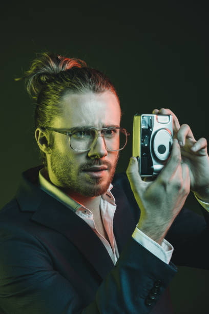 istock young stylish man taking photo on point-and-shoot camera 698833614