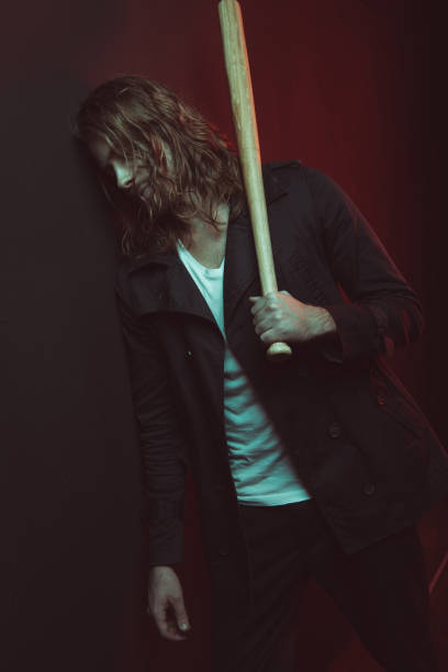 istock Stylish long haired man holding baseball bat and looking down 698835572
