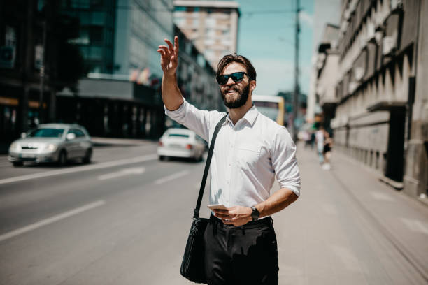 istock Businessman with sunglasses is hailing an uber. 698844660