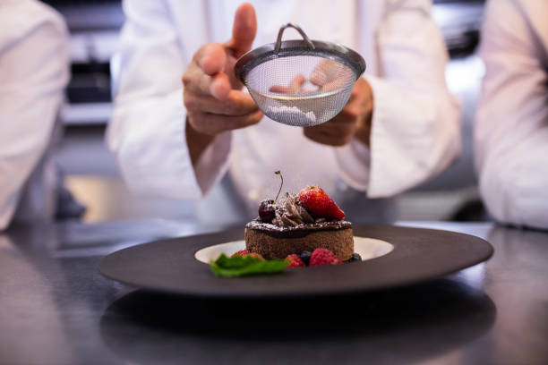 Chefs team finishing dessert plates in the kitchen