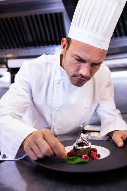 istock Male chef garnishing dessert plate 698845684