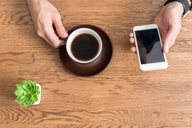 istock Youthful guy having break with hot beverage at kitchen table 698847586