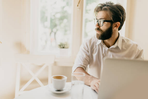 istock Man having his coffee while surfing the net on the laptop 698864152