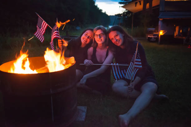 istock Girls celebrating Independence day with campfire at dusk. 698870156