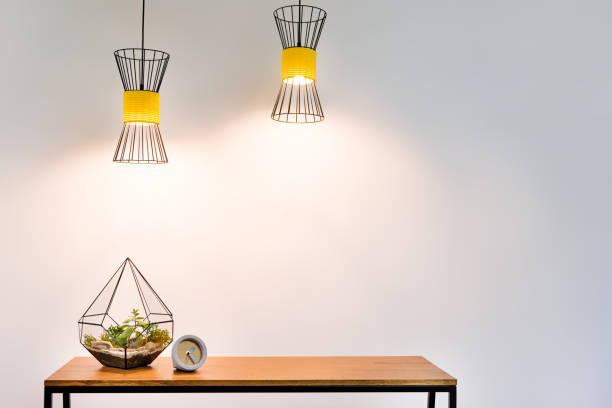 Stylish vase with domestic plant and watch on table surface