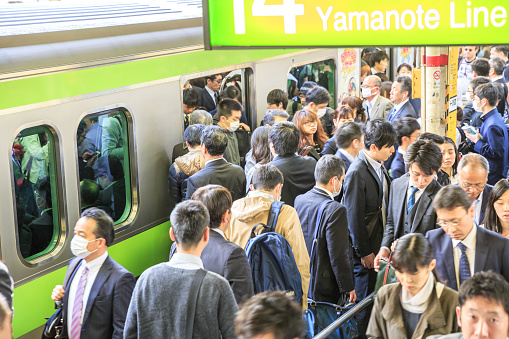 Tokyo, Japan - April 17, 2017: Crowd of commuters ascends and drops from train at rush hour in Shinjuku Station, the city's main station.The Yamanote Line is the most important train line in Tokyo.
