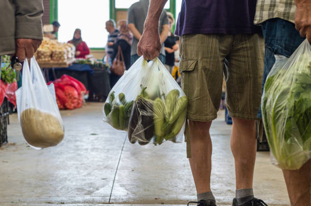 Men holding plastic shopping bag with vegetables in a typical Turkish greengrocery bazaar stock photo