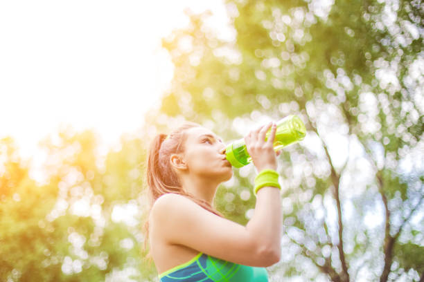 erfrischung nach dem training - exercising sensuality water bottle relaxation exercise stock-fotos und bilder