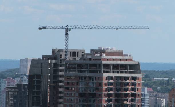 istock Building crane and building under construction against blue sky 698892536