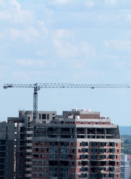 istock Building crane and building under construction against blue sky 698892694