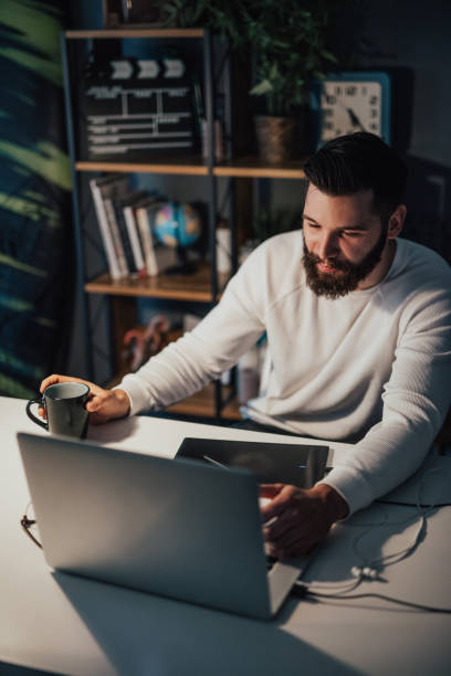 istock Freelancer drinking coffee at the office because long night ahead of him 698893928