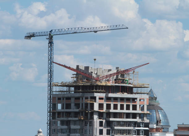 istock Building crane and building under construction against blue sky 698895394