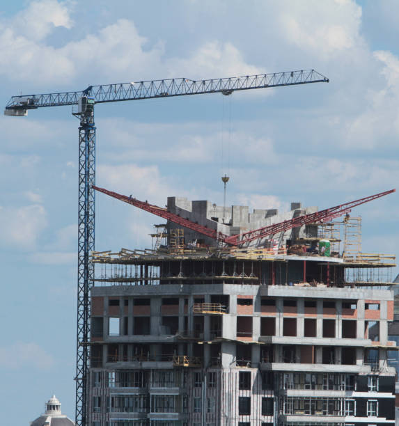 istock Building crane and building under construction against blue sky 698895628
