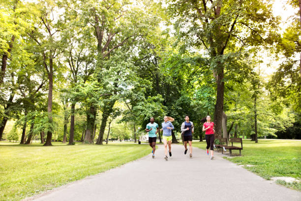 istock Group of young athletes running in green sunny park. 698902956