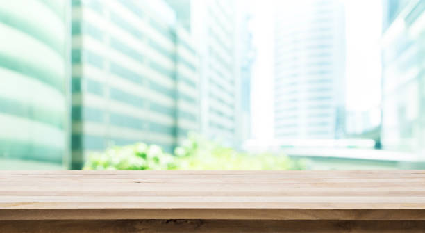 istock Wood table top with building office view background 698904652