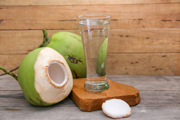 istock Fresh Coconut Water Drink on wooden  background 698925770