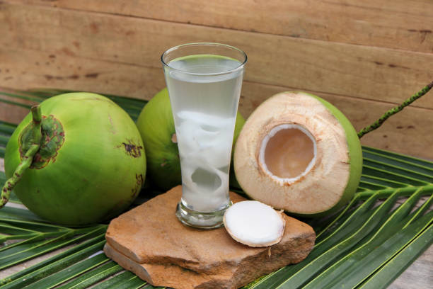 istock Fresh Coconut Water Drink on wooden  background 698925842