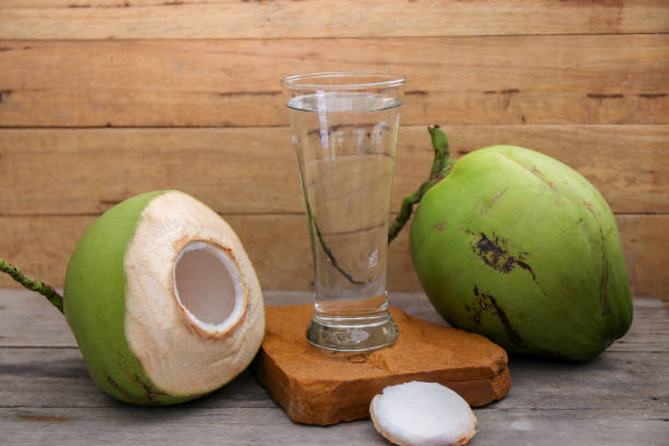 istock Fresh Coconut Water Drink on wooden  background 698926128