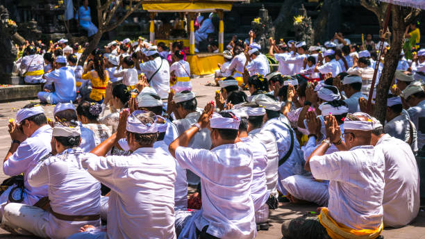 gens qui priaient au cours de la célébration cérémonie balinaise au temple de pura goa lawah, bali, indonésie - pura goa lawah photos et images de collection