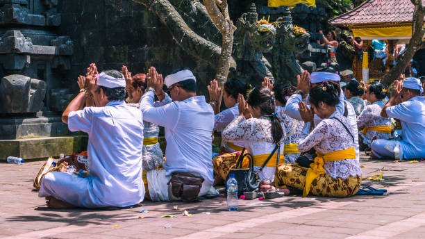 balinais priant sur la cérémonie au temple de pura goa lawah, bali, indonésie - pura goa lawah photos et images de collection