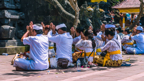 preghiera balinese in cerimonia al tempio pura goa lawah, bali, indonesia - pura goa lawah foto e immagini stock