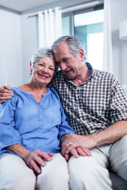 istock Happy senior couple sitting on sofa and embracing 698948878