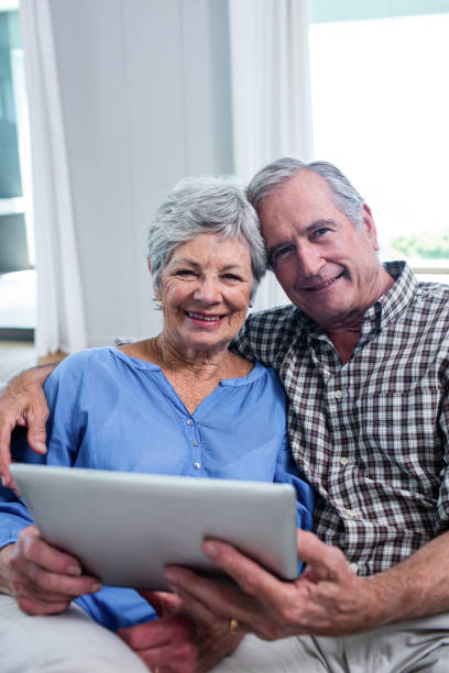 istock Portrait of senior couple using a digital tablet on sofa 698949260