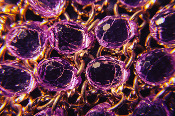 istock Purple plastic jewelry texture with golden chains 698950088
