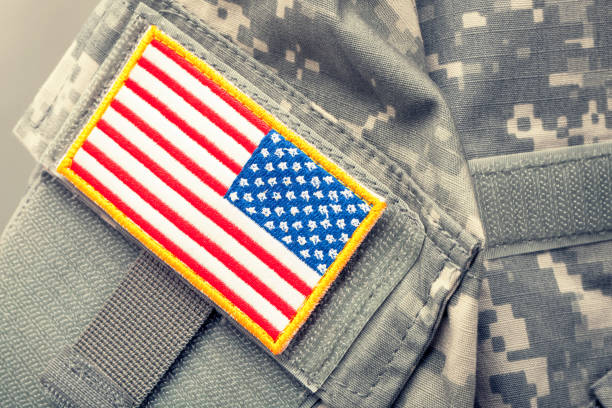 istock USA flag shoulder patch on solder's uniform - studio shot. Filtered image: cross processed vintage effect. 698971406