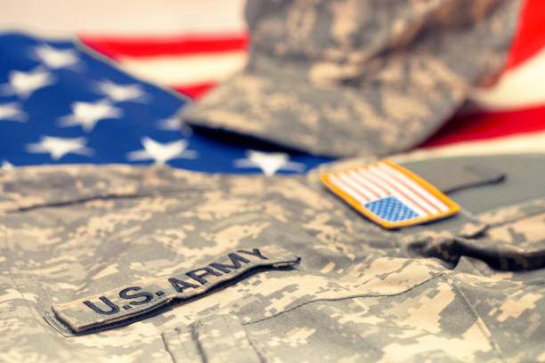 istock USA army uniform lying over national flag - studio shot. Filtered image: cross processed vintage effect. 698971582