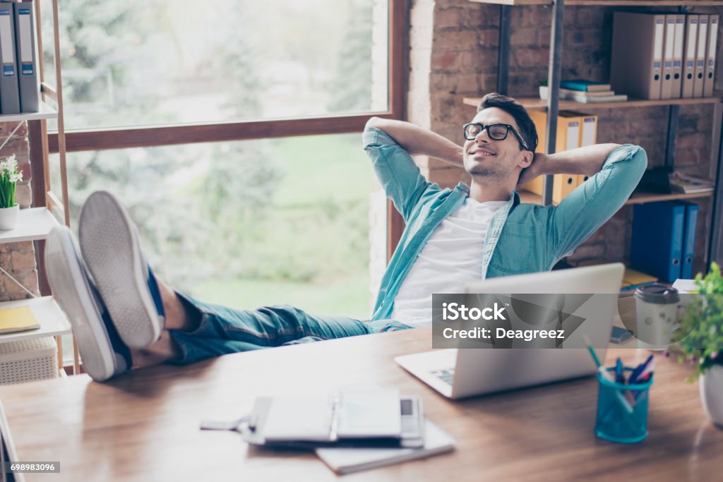 Hombre sonriente tranquilo feliz tener un descanso después de resolver todas las tareas en el trabajo - Foto de stock de Gente tranquila libre de derechos